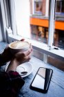 Nahaufnahme der Hand einer Frau mit einer Tasse Kaffee im Café — Stockfoto