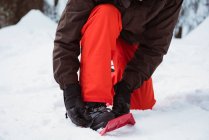 Low section of skier wearing snow shoe on snow covered landscape — Stock Photo