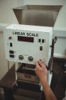 Hand of man using a coffee weighing machine — Stock Photo