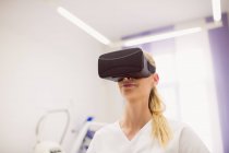 Женщина-врач в наушниках виртуальной реальности в клинике — стоковое фото