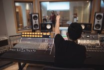 Audio engineer signaling to musicians while recording in studio — Stock Photo