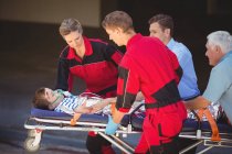 Paramédicos apressando um paciente em emergência na rua — Fotografia de Stock