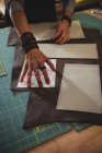 Mid-section of craftswoman arranging leather piece on work table in workshop — Stock Photo