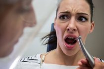 Молода жінка боїться під час стоматологічного огляду в клініці — стокове фото
