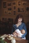 Mãe amorosa segurando bebê bonito nos braços no café — Fotografia de Stock