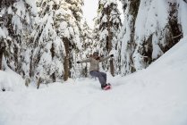 Femme snowboard sur pente enneigée — Photo de stock