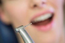 Dentist examining a female patient with tools at dental clinic — Stock Photo