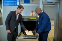 Офіцер аеропорту перевіряє пакет пасажирів в аеропорту — стокове фото