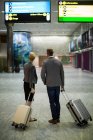 Vista traseira de pessoas de negócios com bagagem no terminal do aeroporto — Fotografia de Stock