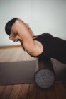 Femme faisant de l'exercice avec rouleau de mousse dans un studio de fitness — Photo de stock