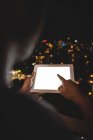 Rückansicht eines Mannes mit digitalem Tablet nachts auf dem Balkon — Stockfoto