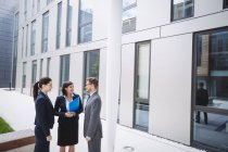 Бизнесмен беседует с коллегами за пределами офисного здания — стоковое фото