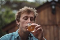 Primer plano del hombre bebiendo cerveza de vaso de cerveza - foto de stock