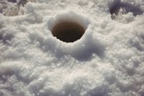 Close-up view of fishing hole in ice on frozen lake — Stock Photo