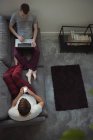 Vista ad alto angolo di coppia gay utilizzando il telefono cellulare e laptop sul divano a casa — Foto stock