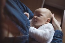 Крупним планом мати тримає сплячу дитину в руках — стокове фото