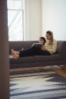 Мать и дочь с помощью цифрового планшета в гостиной дома — стоковое фото