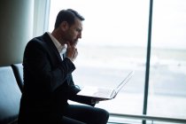 Бізнесмен використовує ноутбук у зоні очікування в терміналі аеропорту — стокове фото