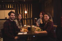 Счастливые друзья наслаждаются едой вместе в баре — стоковое фото
