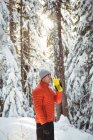 Человек пьет воду из бутылки в лесу зимой — стоковое фото