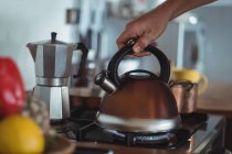 Preparing tea in teakettle on stove in kitchen — Stock Photo