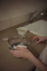 Las manos de la mujer que cuela el azúcar en la cocina - foto de stock