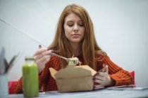 Redhead woman eating salad in the restaurant — Stock Photo