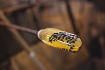 Close-up of molten glass on a blowpipe at glassblowing factory — Stock Photo