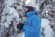 Лыжник с биноклем смотрит на расстояние на снежной горе — стоковое фото