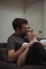 Романтична гей пара обіймається на дивані у вітальні вдома — стокове фото