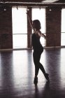 Jeune femme exécutant la danse moderne en studio de danse — Photo de stock