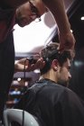 Barbiere maschio taglio capelli cliente con trimmer in barbiere — Foto stock