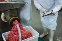 Carne picada fresca na máquina de picar na fábrica de carne — Fotografia de Stock