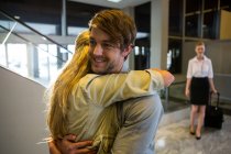 Fröhliches Paar umarmt sich im Flughafen-Terminal — Stockfoto