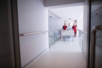 Врачи переносят неотложные носилки в коридоре больницы — стоковое фото