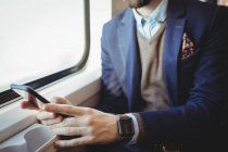 Mittelteil des Geschäftsmannes benutzt Handy während der Zugfahrt — Stockfoto