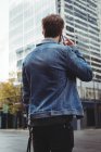 Visão traseira do homem falando no telefone celular enquanto está de pé na rua — Fotografia de Stock
