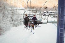 Casal de esquiadores viajando em teleférico em estância de esqui — Fotografia de Stock