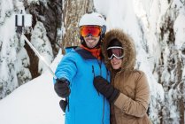 Счастливая пара лыжников делает селфи на снежном ландшафте — стоковое фото