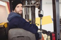 Портрет механіка, що сидить на навантажувачі в ремонтному гаражі — стокове фото