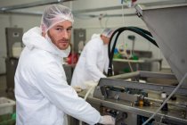 Retrato de açougueiro operando máquina na fábrica de carne — Fotografia de Stock