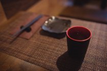 Copa de sake en mesa de comedor en el restaurante - foto de stock