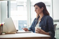 Führungskräfte nutzen Laptop bei einer Tasse Kaffee im Büro — Stockfoto