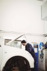 Carro de manutenção mecânica na garagem de reparação — Fotografia de Stock
