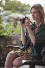Красивая женщина фотографирует цифровым фотоаппаратом — стоковое фото