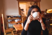 Donna che beve caffè in caffetteria — Foto stock