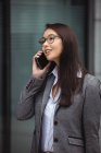 Geschäftsfrau telefoniert vor Bürogebäude — Stockfoto