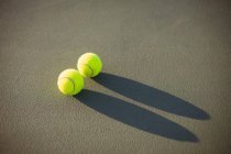 Close-up of tennis balls kept on court in sunlight — Stock Photo