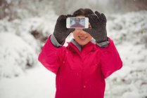 Donna sorridente scattare selfie sul telefono cellulare durante l'inverno — Foto stock