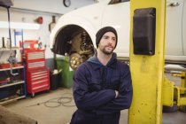 Mécanicien debout avec bras croisés dans le garage de réparation — Photo de stock